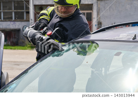 Firefighter Using Hydraulic Cutter To Extricate Passenger From Crashed Car Windshield During Rescue Firefighter Using Hydraulic Cutter To Extricate Passenger From Crashed Car Windshield During Rescue 143013944