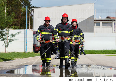 Firefighters Walking Confidently in Uniform With Helmets During Emergency Response Training Exercise Firefighters Walking Confidently in Uniform With Helmets During Emergency Response Training Exercise 143014039