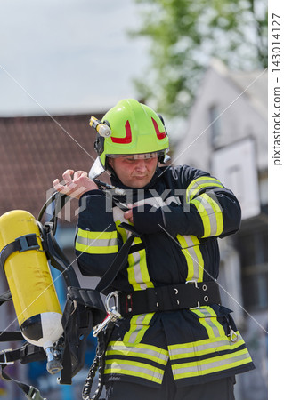 Firefighter In High-Visibility Gear Wearing Helmet And Breathing Apparatus During Emergency Response Training Firefighter In High-Visibility Gear Wearing Helmet And Breathing Apparatus During Emergency Response Training 143014127