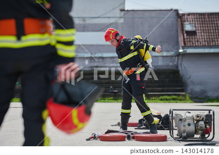 Firefighter Training Drill With Protective Gear And Breathing Apparatus During Urban Rescue Exercise Firefighter Training Drill With Protective Gear And Breathing Apparatus During Urban Rescue Exercise 143014178