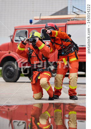 Firefighters With Thermal Camera and Fire Truck Teamwork During Emergency Rescue Training Exercise Firefighters With Thermal Camera and Fire Truck Teamwork During Emergency Rescue Training Exercise 143014222