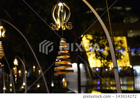 Golden spiral light decoration illuminates a dark festive night Golden spiral light decoration illuminates a dark festive night 143014272