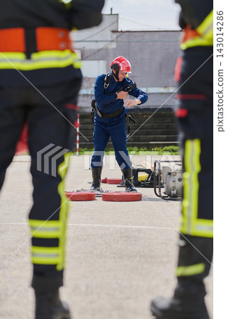 Firefighter Training Drill With Helmeted Rescue Worker Practicing Safety and Equipment Handling During Emergency Exercise 143014286