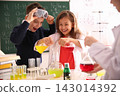 Smart pupils making experiment in chemistry class 143014392