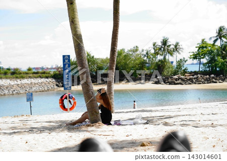 Woman relaxing on a beautiful tropical beach Woman relaxing on a beautiful tropical beach 143014601