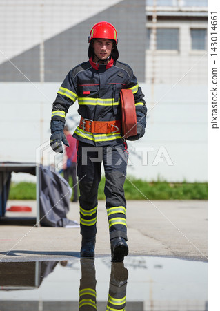 Front View Of Firefighter In Full Gear Carrying Hose During Emergency Training Exercise 143014661