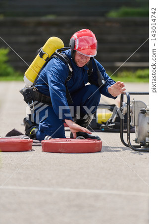 Firefighter Training With Breathing Apparatus And Hose Reels During Emergency Preparedness Drill Firefighter Training With Breathing Apparatus And Hose Reels During Emergency Preparedness Drill 143014742
