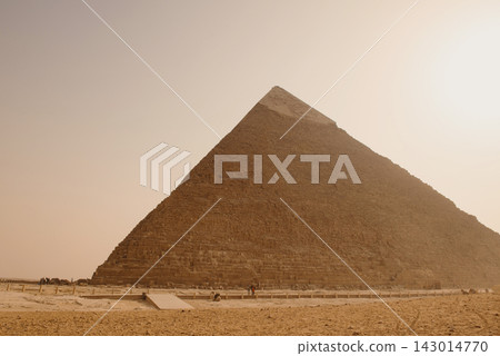Great Pyramid of Giza massive limestone stonework rising over giza plateau sandy foreground under diffused overcast hazy sky Egypt travel and heritage Great Pyramid of Giza massive limestone stonework rising over giza plateau sandy foreground under diffused overcast hazy sky Egypt travel and heritage 143014770