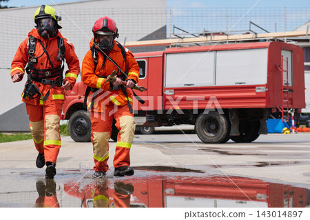 Firefighters In Protective Gear Running From Fire Truck During Emergency Response And Rescue Drill Firefighters In Protective Gear Running From Fire Truck During Emergency Response And Rescue Drill 143014897