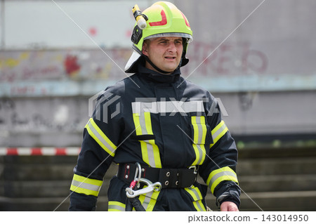 Male Firefighter in Protective Gear With Helmet and Rope During Urban Emergency Response Male Firefighter in Protective Gear With Helmet and Rope During Urban Emergency Response 143014950