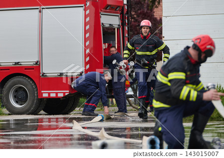 Firefighters Working With Fire Truck And Hoses During Emergency Response Training Drill 143015007