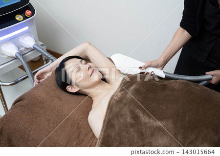 Women getting underarm hair removal at a salon Women getting underarm hair removal at a salon 143015664