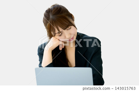一位女商人一邊用電腦一邊思考 143015763