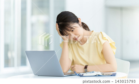 一位女商人一邊用電腦一邊思考 一位女商人一邊用電腦一邊思考 143015793