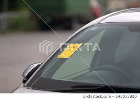 A passenger car with an abandoned vehicle confirmation sticker attached. A passenger car with an abandoned vehicle confirmation sticker attached. 143015920