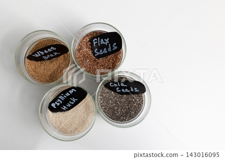 Flax seeds in jars arranged on a white surface for dietary fiber Flax seeds in jars arranged on a white surface for dietary fiber 143016095