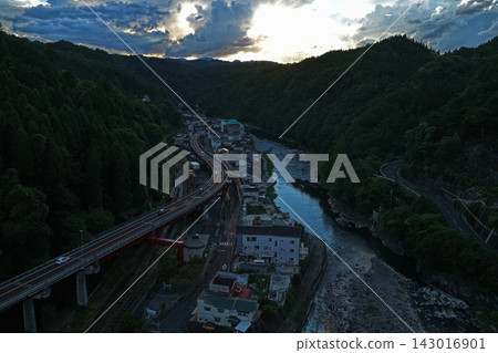 一張傍晚的空拍照片,展現了大分縣日田市的河流、高架橋和山區。 一張傍晚的空拍照片,展現了大分縣日田市的河流、高架橋和山區。 143016901