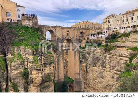 Puente Nuevo dramatic bridge spanning a deep limestone gorge creating iconic architectural landmark in Ronda, Spain. Puente Nuevo dramatic bridge spanning a deep limestone gorge creating iconic architectural landmark in Ronda, Spain. 143017154
