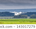 White passenger turboprop airplane takes off runway in cloudy weather 143017279
