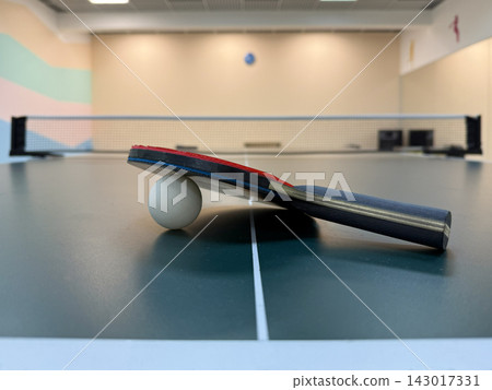 Table tennis. The racket with the sword is lying on the table. Sports ball games. Sports equipment for training, competitions, and active recreation. Table tennis. The racket with the sword is lying on the table. Sports ball games. Sports equipment for training, competitions, and active recreation. 143017331