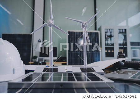 Two Asian engineers wearing hardhats and safety vests discussing solar panel installation and renewable energy project in the office. Two Asian engineers wearing hardhats and safety vests discussing solar panel installation and renewable energy project in the office. 143017561