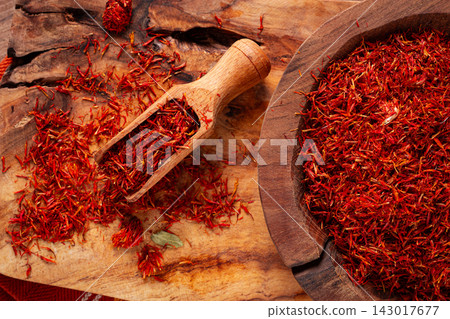 Spice saffron threads, in a wooden bowl, on a wooden table, top view, close-up, Spice saffron threads, in a wooden bowl, on a wooden table, top view, close-up, 143017677