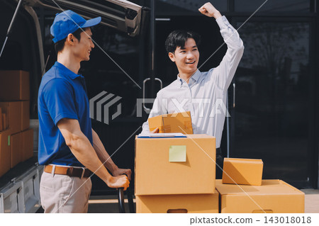 Young businessman signing a delivery receipt document on a clipboard held by a courier in a blue uniform. Young businessman signing a delivery receipt document on a clipboard held by a courier in a blue uniform. 143018018