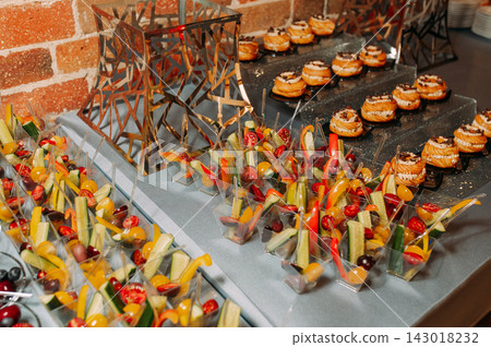 Colorful appetizer cups and mini pastries at a catered buffet Colorful appetizer cups and mini pastries at a catered buffet 143018232
