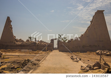 Ancient Egyptian temple ruins with stone pylon and pathway Ancient Egyptian temple ruins with stone pylon and pathway 143018567