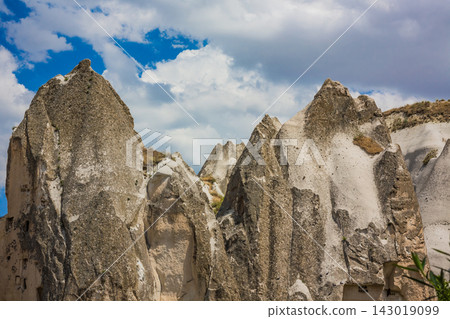 Jagged rock formations under a blue sky with white clouds Jagged rock formations under a blue sky with white clouds 143019099