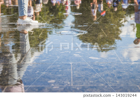 Little happy children have fun in the outdoor fountain on hot days. Teenagers and children running among the city fountains Little happy children have fun in the outdoor fountain on hot days. Teenagers and children running among the city fountains 143019244