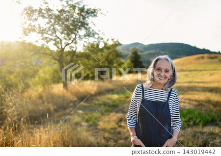 Senior woman enjoying gentle outdoor activity and connection with nature. Senior woman enjoying gentle outdoor activity and connection with nature. 143019442