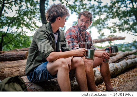 Father and teenage son resting during trip, having coffee. Father and teenage son resting during trip, having coffee. 143019462