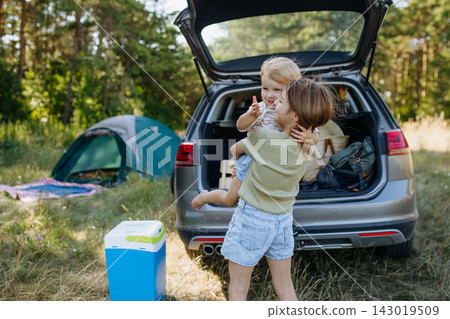 Family getting camping equipment from car after arriving in nature. Family getting camping equipment from car after arriving in nature. 143019509