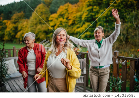 Senior women enjoying friendship and autumn day on terrace. Senior women enjoying friendship and autumn day on terrace. 143019585