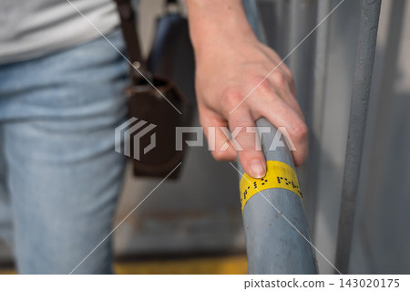 A blind woman reads the inscription on the railing of a staircase. A blind woman reads the inscription on the railing of a staircase. 143020175