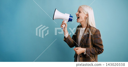 Mature woman shouting announcement using megaphone 143020338