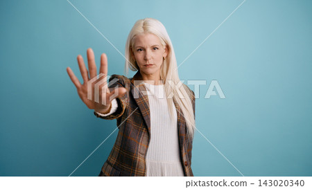 Woman serious expression making stop gesture with hand Woman serious expression making stop gesture with hand 143020340