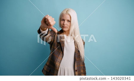 Woman giving thumbs down expressing disapproval Woman giving thumbs down expressing disapproval 143020341