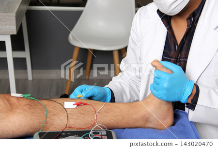Electromyography in the lower limbs, graphic recording technique of the electrical activity produced by the tibial muscle performed by a specialist neurologist Electromyography in the lower limbs, graphic recording technique of the electrical activity produced by the tibial muscle performed by a specialist neurologist 143020470