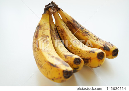 A bunch of ripe bananas with sugar spots placed against a white background. A bunch of ripe bananas with sugar spots placed against a white background. 143020534
