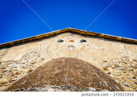 Ancient church roofline detail with stone wall, Crete, Greece Ancient church roofline detail with stone wall, Crete, Greece 143021938