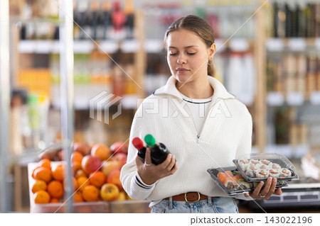 European woman chooses soy sauce for sushi European woman chooses soy sauce for sushi 143022196