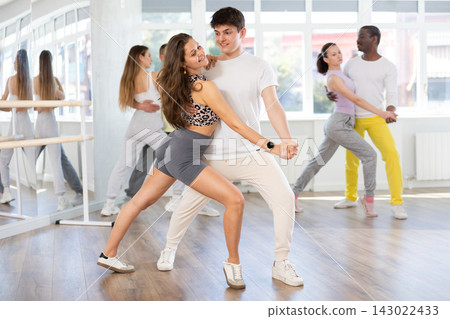 Young woman dances incendiary tango with man partner during choreography lesson Young woman dances incendiary tango with man partner during choreography lesson 143022433