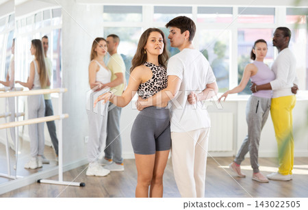 Young man and woman practicing waltz dance in pair in training hall Young man and woman practicing waltz dance in pair in training hall 143022505