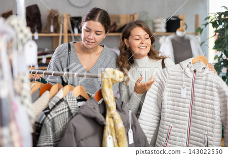 Two young women choosing outerwear in store Two young women choosing outerwear in store 143022550