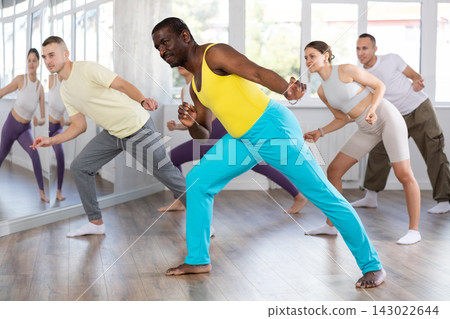 African american male instructor leading fitness class African american male instructor leading fitness class 143022644