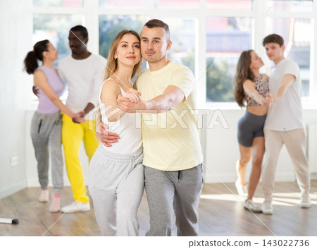 Young man and woman practicing waltz dance in pair in training hall Young man and woman practicing waltz dance in pair in training hall 143022736
