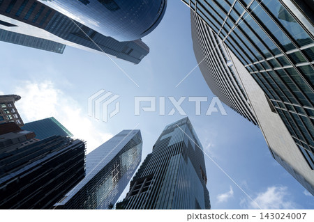 Singapore CBD skyscrapers towering above captured from dramatic low angle perspective Singapore CBD skyscrapers towering above captured from dramatic low angle perspective 143024007