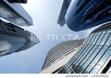 Dramatic low angle view Singapore CBD skyscrapers towering against cloudy sky Dramatic low angle view Singapore CBD skyscrapers towering against cloudy sky 143024010